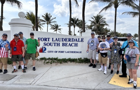Travelers standing in front of the Fort Lauderdale South beach sign
