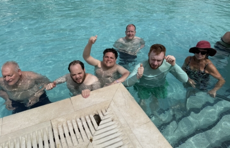 Travelers and staff swimming at Resort pool in Curacao