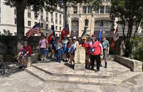 Travelers in front of the 6 flags over Texas