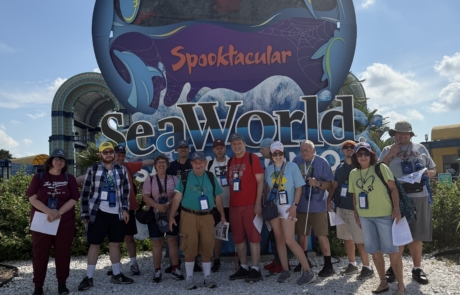 the travelers in front of the Howl-O-Scream SeaWorld sign